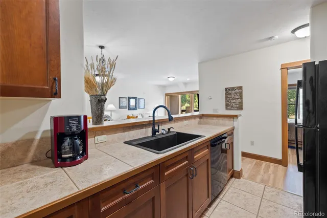 a kitchen with a sink refrigerator and cabinets
