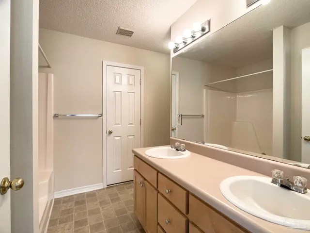 a bathroom with a double vanity sink a mirror and a shower