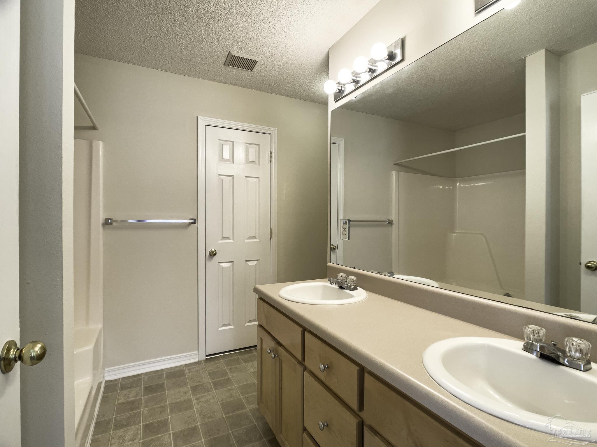 1267 Sterling Point Place Gulf Breeze, FL 32563 - Photo 14 of 27 a bathroom with a double vanity sink a mirror and a shower
