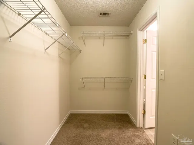 a view of a big room with windows and chandelier fan