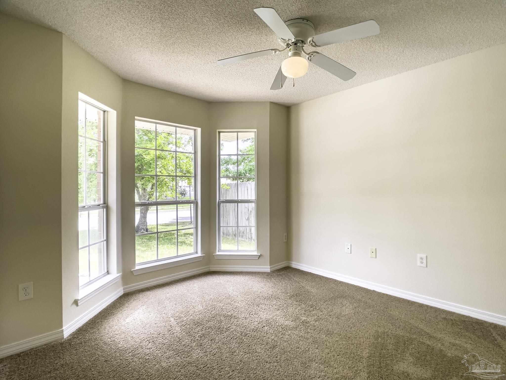 1267 Sterling Point Place Gulf Breeze, FL 32563 - Photo 18 of 27 a view of a big room with windows and chandelier fan