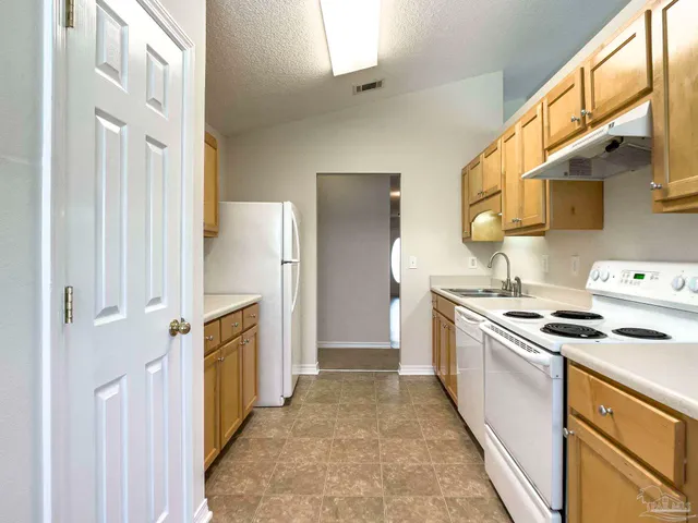 a kitchen with a stove top oven sink and refrigerator