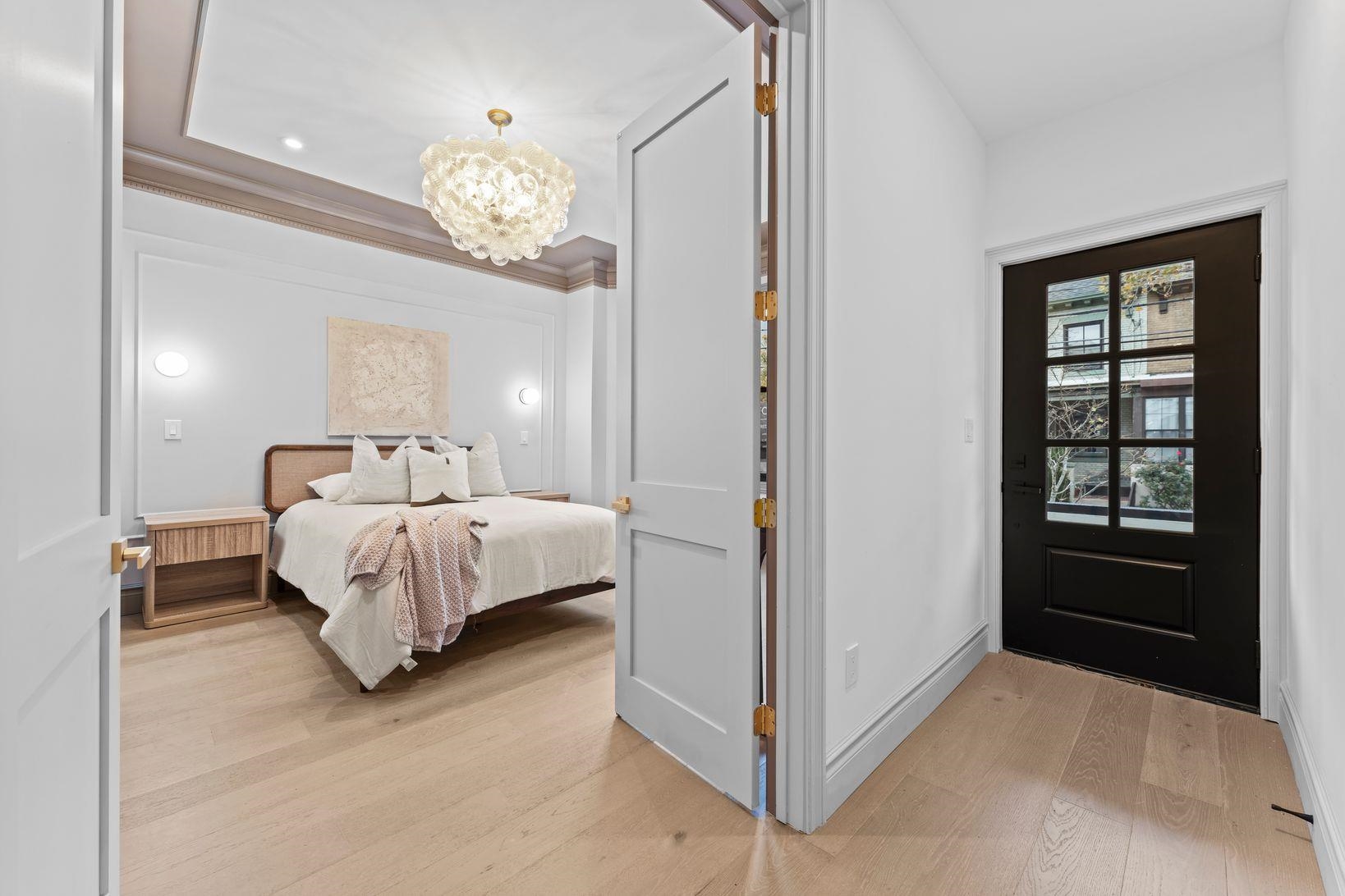 83 Liberty Place, Unit 1 Weehawken, NJ 07086 - Photo 15 of 39 a bed room with a bed and a chandelier