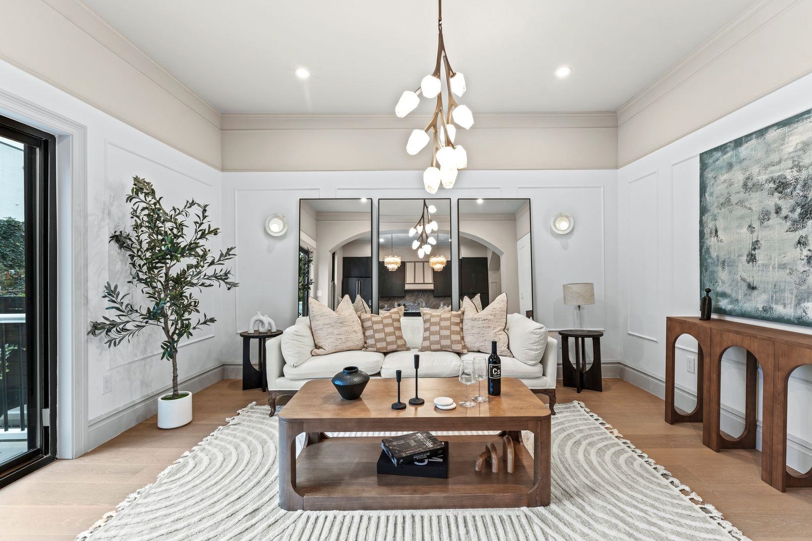 83 Liberty Place, Unit 1 Weehawken, NJ 07086 - Photo 2 of 39 a living room with furniture a chandelier and a rug