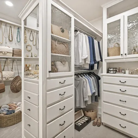 a large white kitchen with stainless steel appliances granite countertop a large stove a sink dishwasher and white cabinets with wooden floor