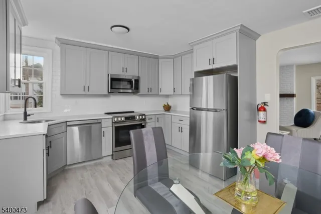 a kitchen with stainless steel appliances a stove a sink cabinets and a refrigerator