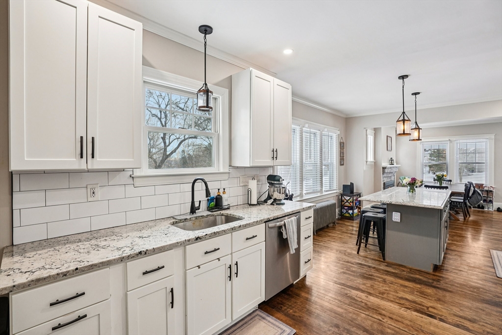 14 Balder Road Worcester, MA 01605 - Photo 12 of 34 a large white kitchen with granite countertop a sink dishwasher a dining table chairs and cabinets