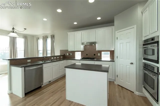 a kitchen with stainless steel appliances granite countertop a stove and a refrigerator