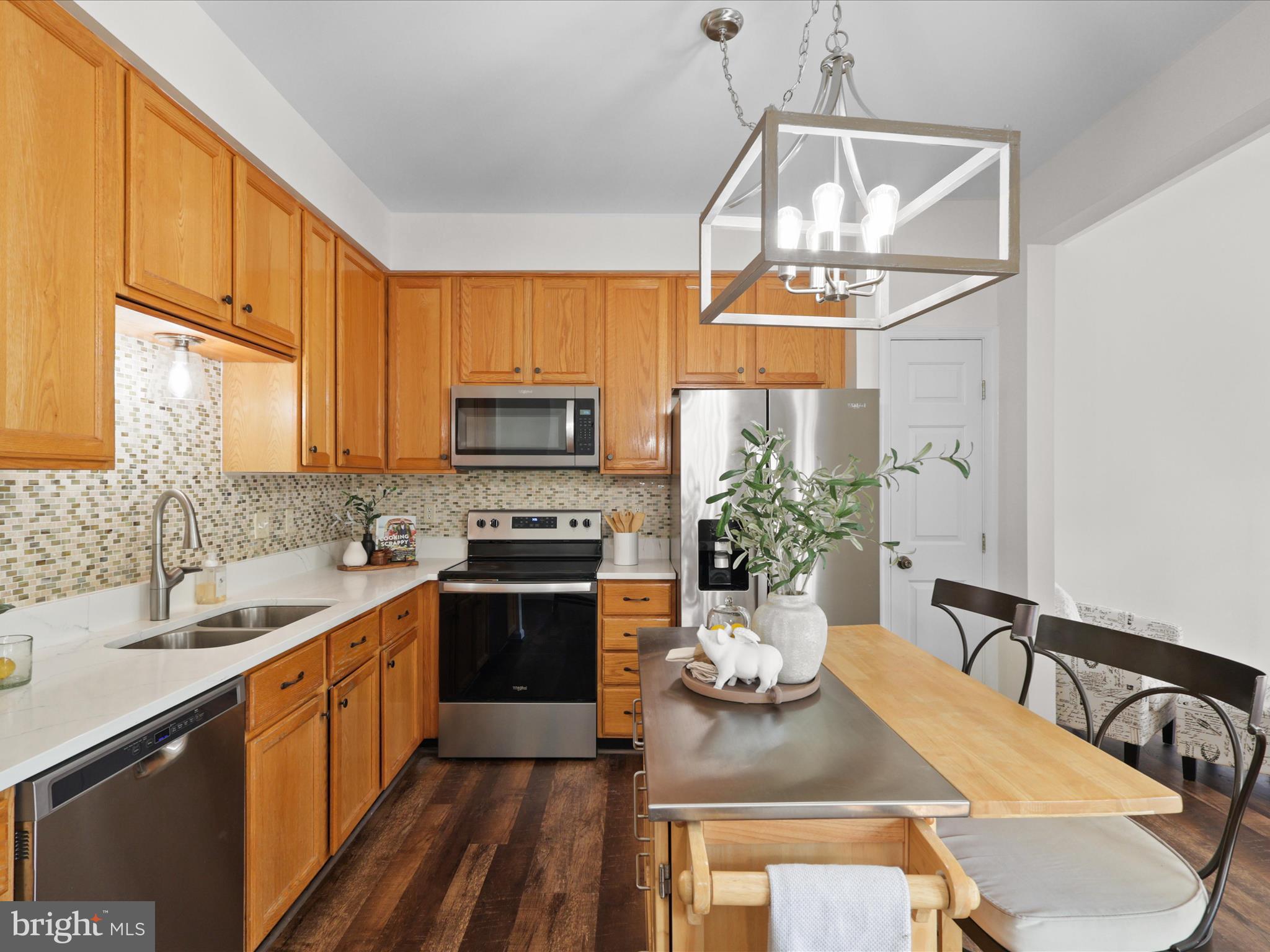 25449 Morse Drive Chantilly, VA 20152 - Photo 9 of 46 a kitchen with a stove a sink a microwave a dining table and chairs