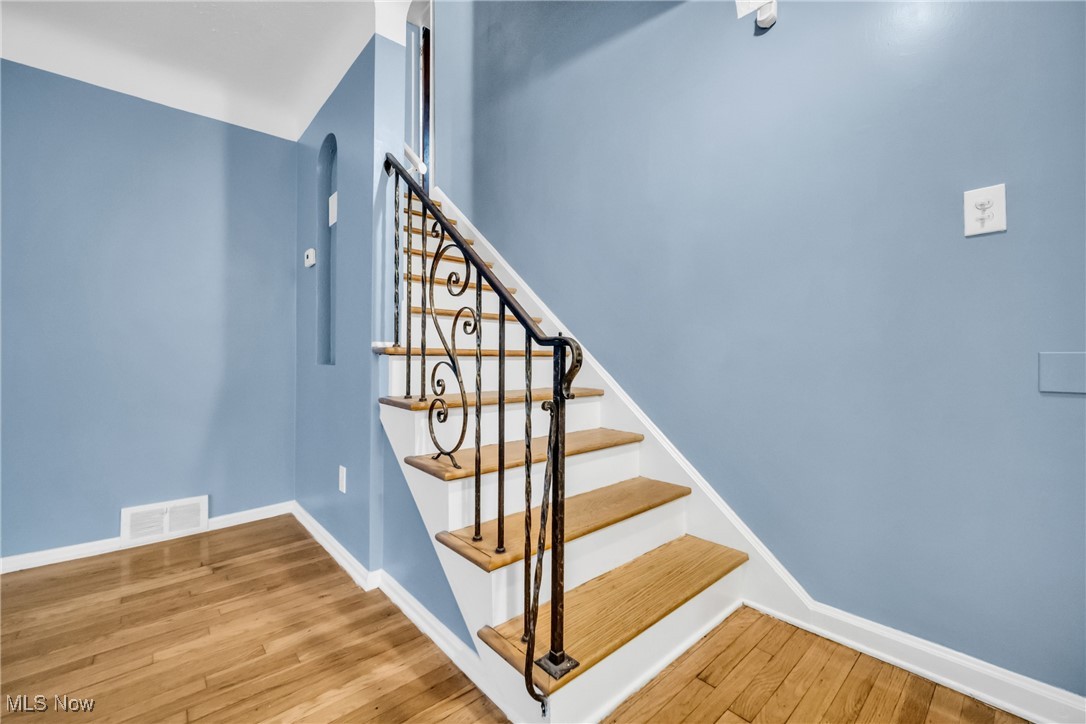 1605 Laclede Road Cleveland, OH 44121 - Photo 30 of 40 Staircase with wood finished floors, visible vents, and baseboards
