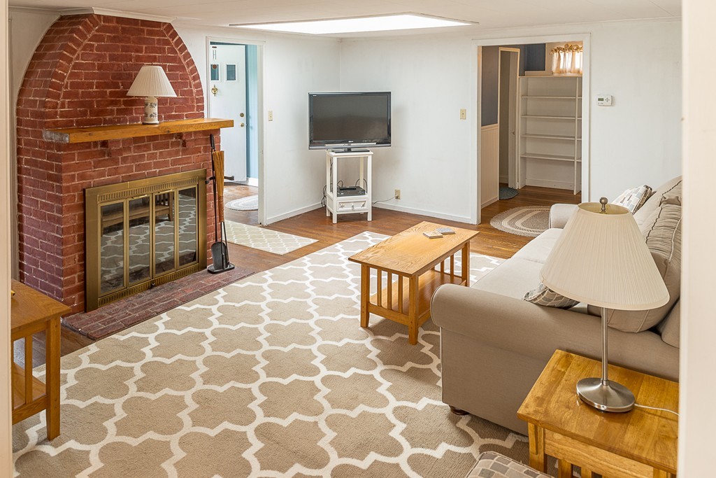 32 Bayview Road Marblehead, MA 01945 - Photo 2 of 12 a living room with furniture a flat screen tv and a fireplace