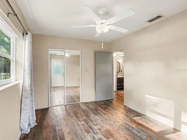an empty room with wooden floor and windows