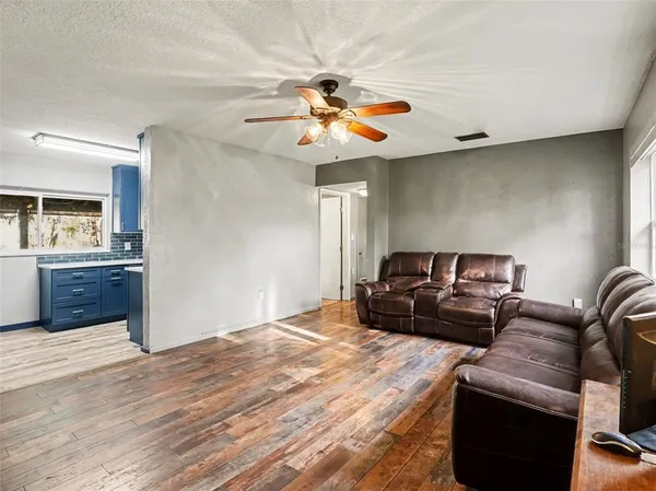 a living room with furniture and a wooden floor
