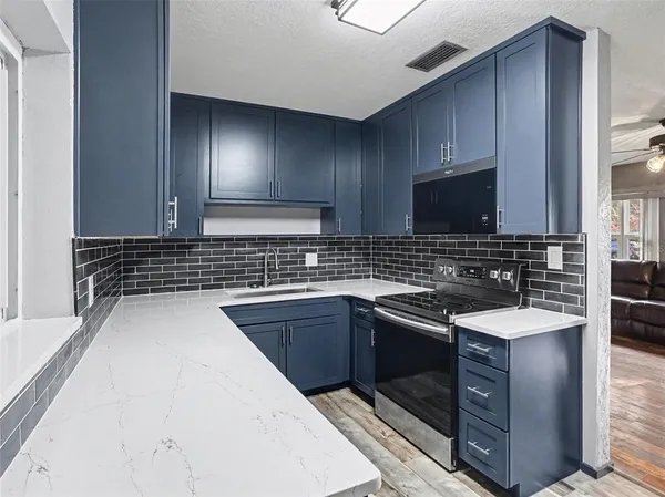 a kitchen with stainless steel appliances granite countertop a sink stove and microwave
