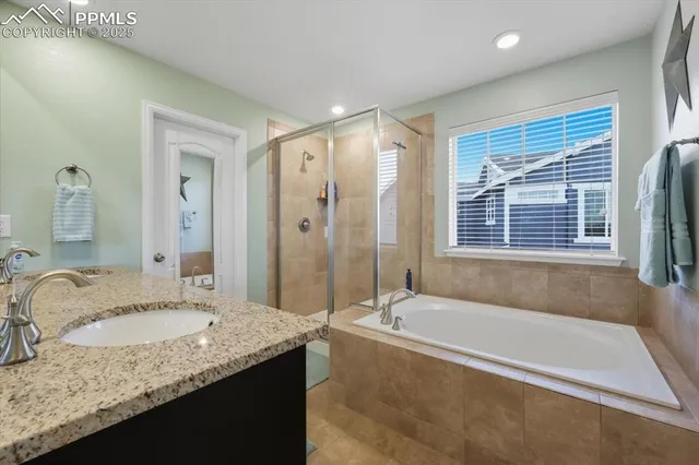 a bathroom with a granite countertop tub sink and mirror