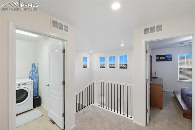 a view of a hallway to a livingroom with furniture and windows