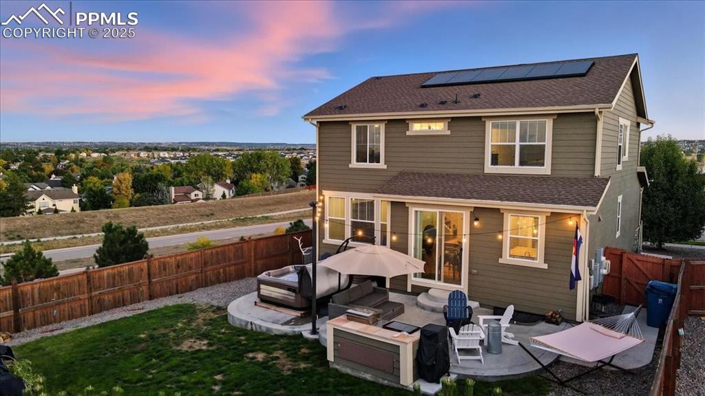 10539 Casper Point Parker, CO 80134 - Photo 26 of 35 Back of house featuring roof with shingles, solar panels, a patio area, a fenced backyard, and outdoor lounge area