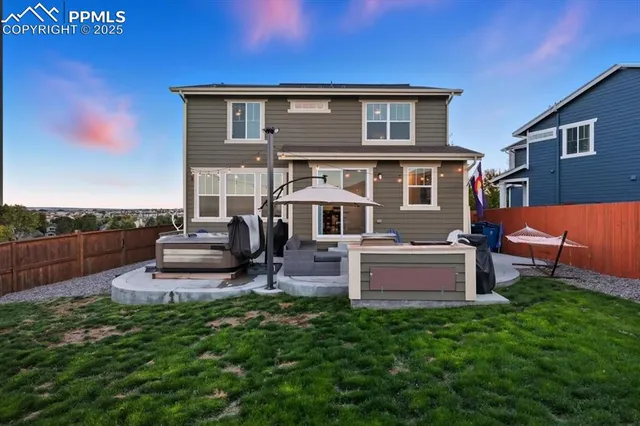 a front view of a house with a garden and chairs