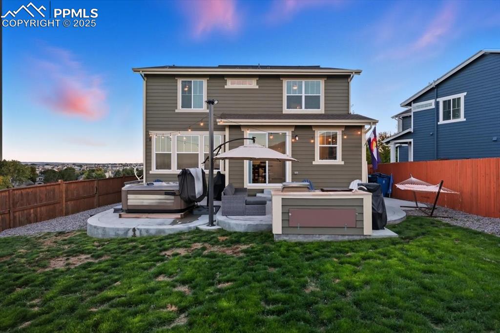 10539 Casper Point Parker, CO 80134 - Photo 31 of 35 Back of house at dusk featuring a hot tub, a fenced backyard, a patio area, and a gazebo