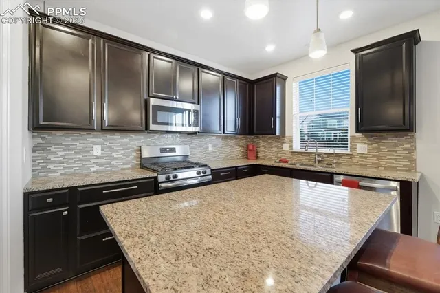 a kitchen with stainless steel appliances granite countertop a sink stove and microwave