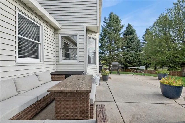 a view of a patio with a table and chairs and potted plants