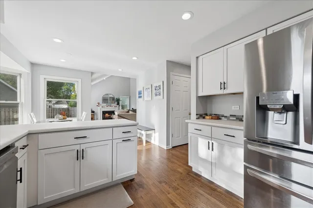 a kitchen with stainless steel appliances white cabinets and wooden floors