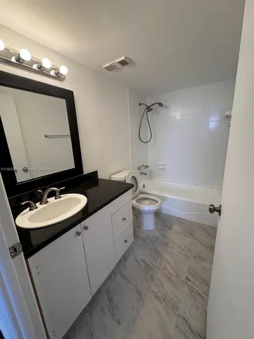 a bathroom with a double vanity sink mirror and toilet