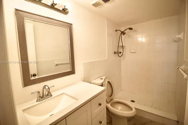 a bathroom with a sink toilet and shower