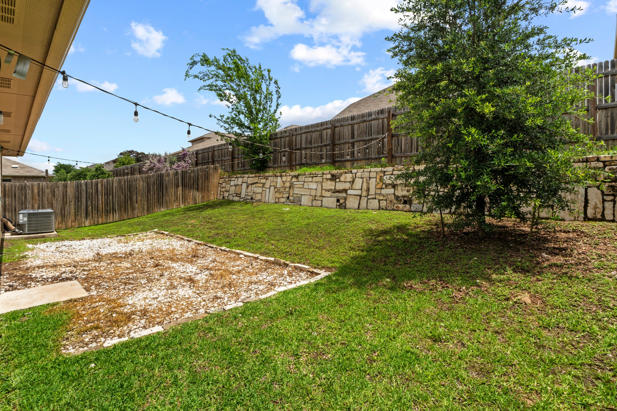 10809 Gonzales Ranger Pass Austin, TX 78754 - Photo 5 of 37 Outside, the fenced backyard offers a rare sense of privacy thanks to its elevated rear boundary, stone retaining wall, and tall fencing.