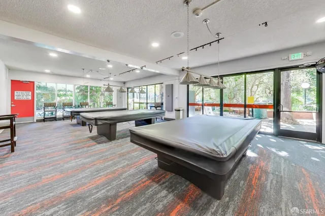 a living room with furniture a table and large windows