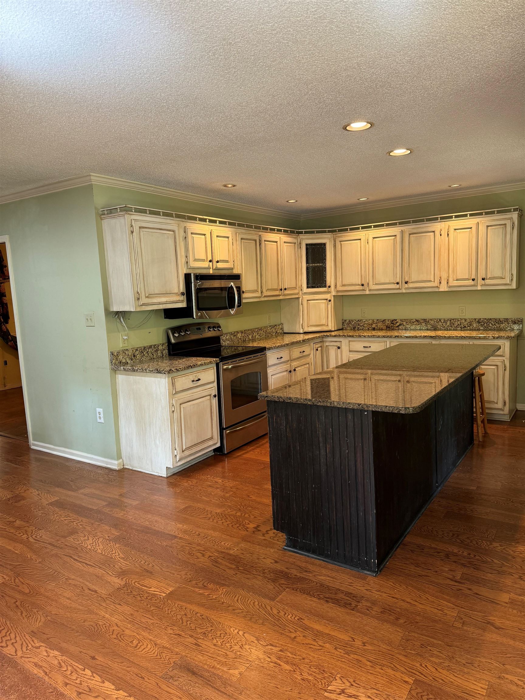 6738 River Birch Road Memphis, TN 38119 - Photo 4 of 17 Kitchen with dark wood-type flooring, ornamental molding, a center island, and appliances with stainless steel finishes