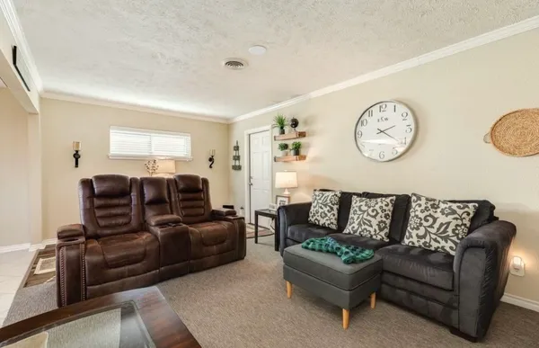 a living room with furniture a clock on wall and a window
