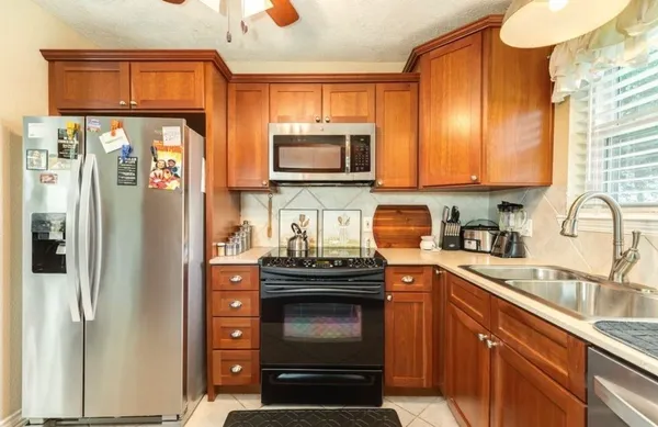 a kitchen with stainless steel appliances granite countertop a stove a refrigerator and a sink
