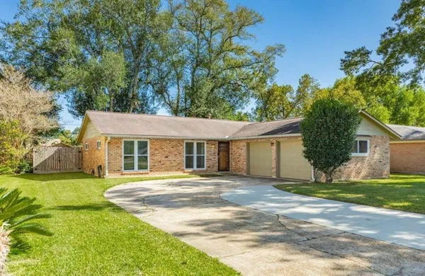 a front view of a house with a yard and trees