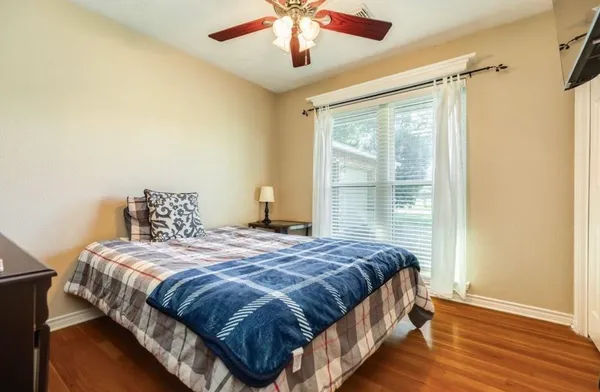 a bedroom with a large bed chandelier and a window