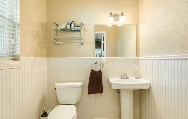 a bathroom with a sink and mirror with toilet
