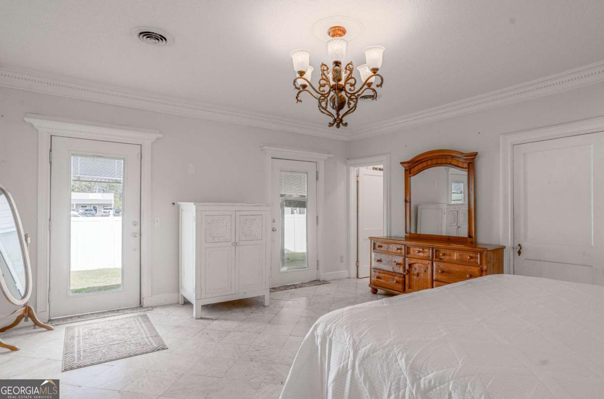 316 Fair Street Baxley, GA 31513 - Photo 15 of 64 a bedroom with a bed and a chandelier