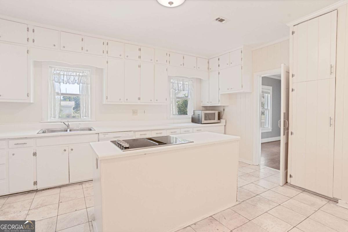 316 Fair Street Baxley, GA 31513 - Photo 10 of 64 a kitchen with white cabinets and white appliances
