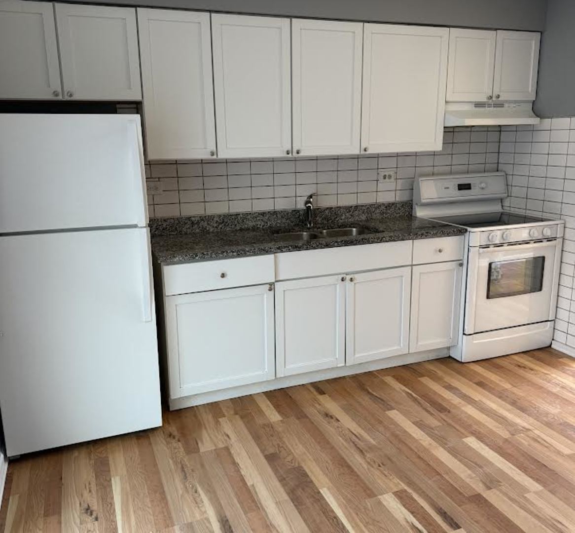 7719 South Roberts Road Bridgeview, IL 60455 - Photo 2 of 10 a kitchen with granite countertop white cabinets and white appliances