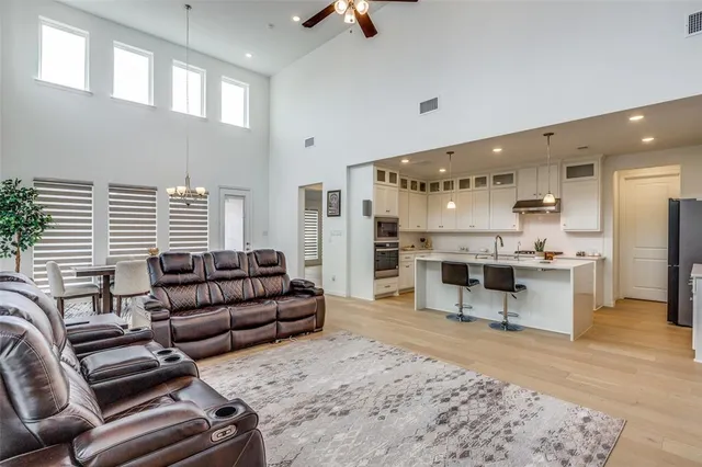 a living room with furniture kitchen view and a large window