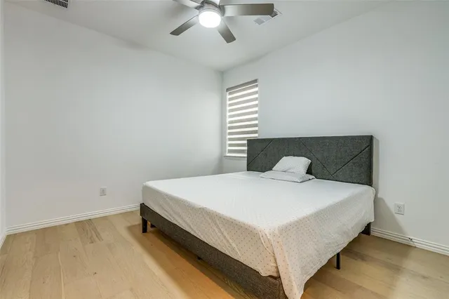 a large bed sitting in a bedroom next to a window