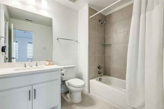 a bathroom with a bathtub shower sink vanity mirror and toilet