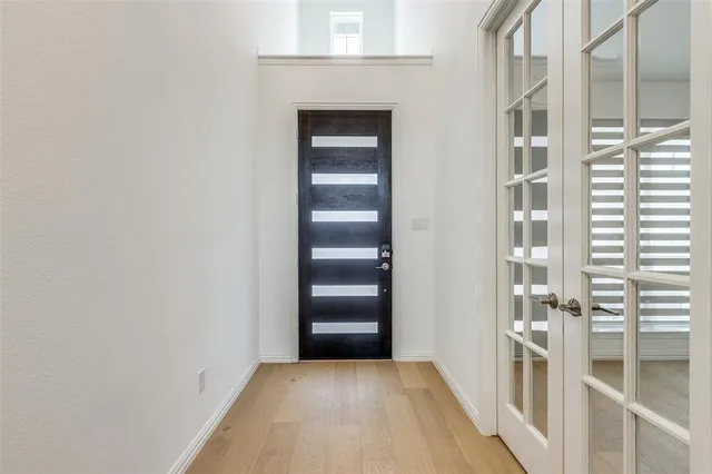 a view of a hallway with wooden floor and entryway