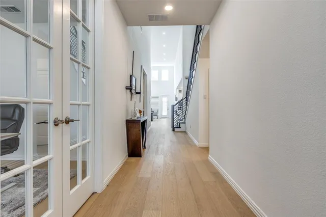 a view of a hallway with wooden floor and staircase