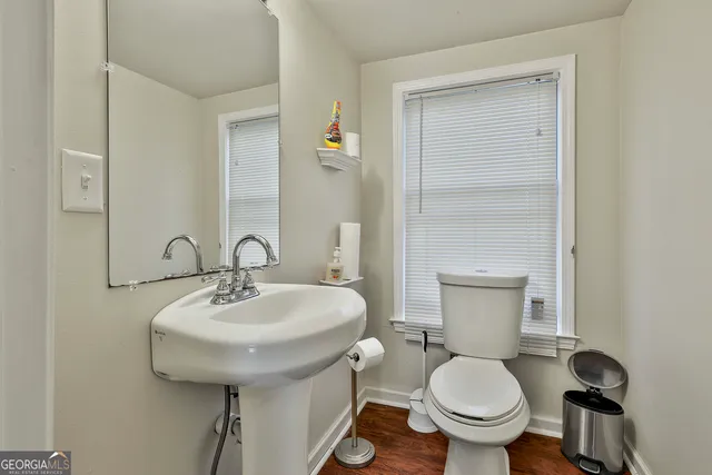 a bathroom with a sink toilet and a mirror