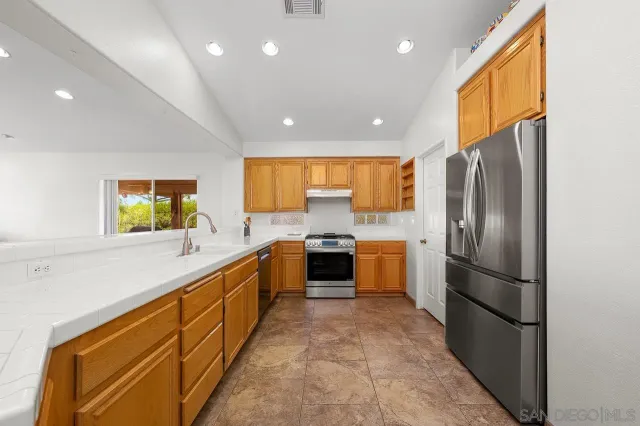 a large kitchen with a large window and stainless steel appliances