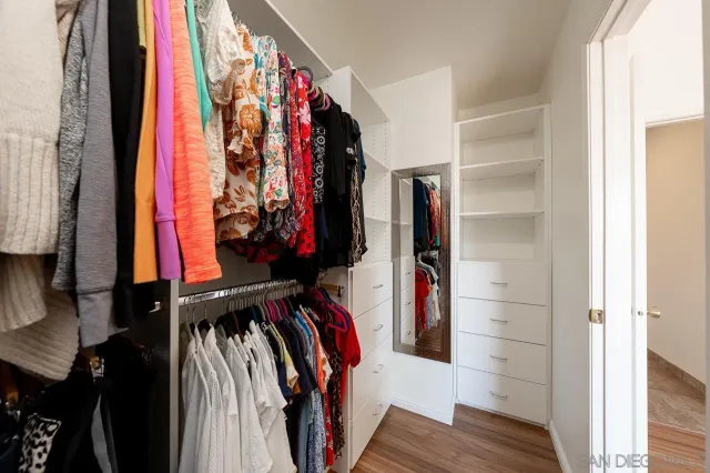 a view of walk in closet with clothes and shoes