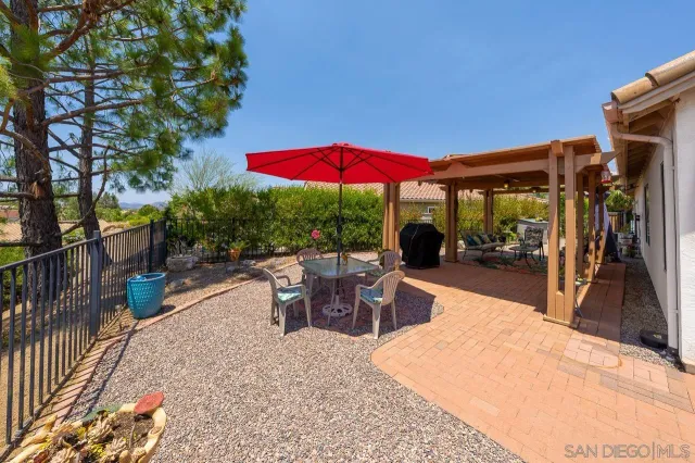 a view of a patio with a table and chairs under an umbrella