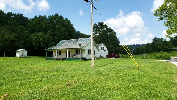 a view of a house with backyard and garden