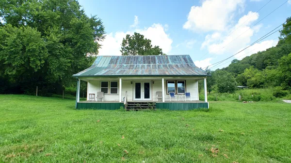 a front view of house with garden and trees